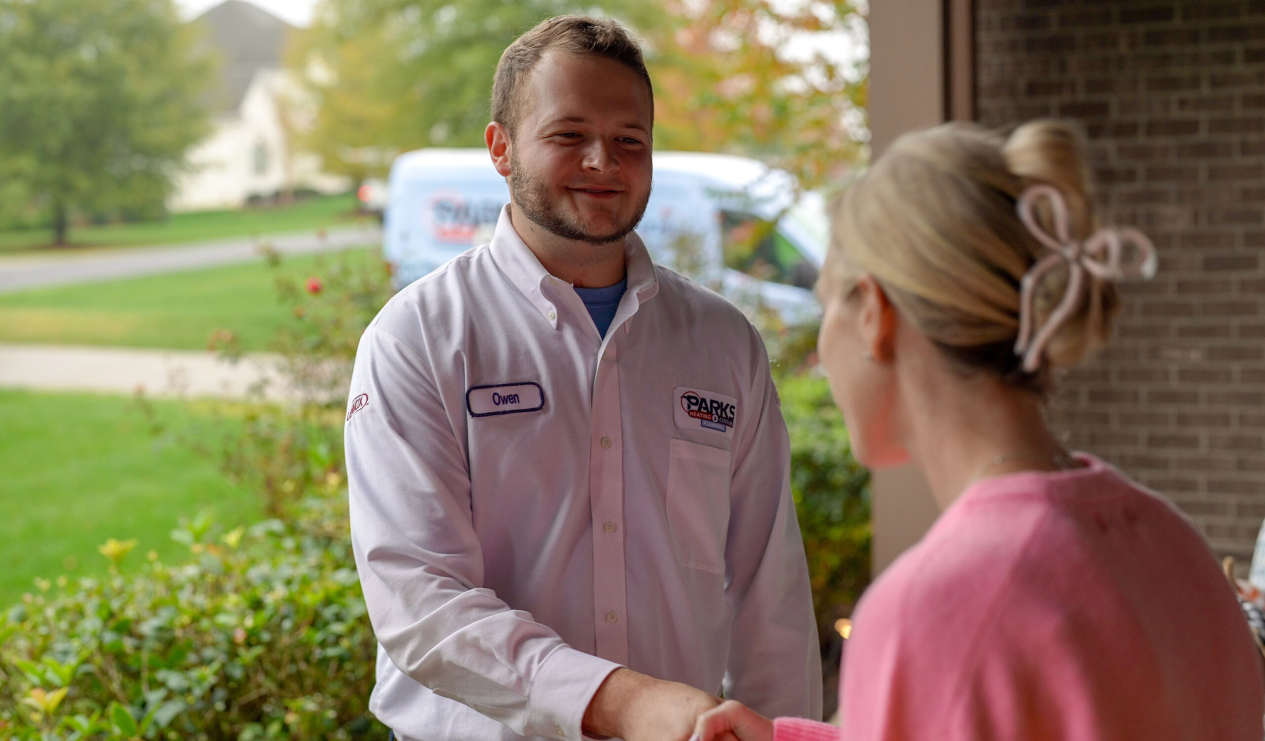 Parks HVAC technician smiling in front of a customer's home