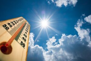 Thermometer showing high temperatures while sun shines brightly