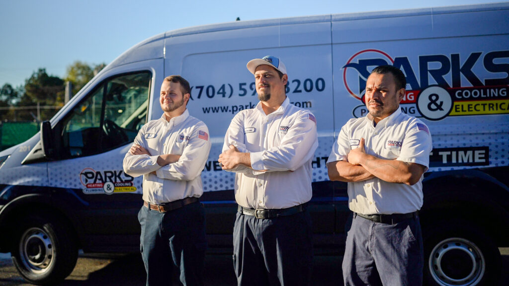 Three Parks technicians standing beside a Parks service van
